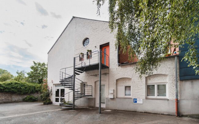 Ansicht eines modernen Praxisgebäudes mit Außentreppe und barrierefreiem Zugang als Teil eines Webdesign-Projekts für Ärzte.